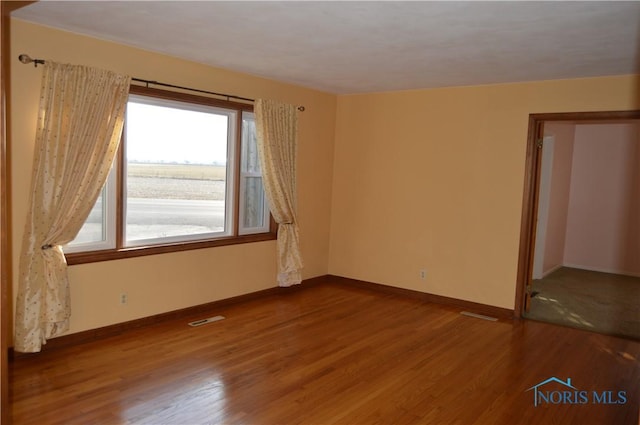 spare room with wood-type flooring