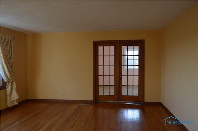 empty room featuring dark wood-type flooring and french doors