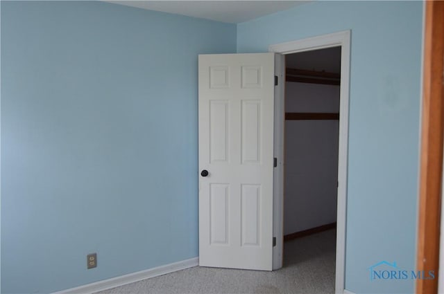 unfurnished bedroom featuring a closet and light colored carpet