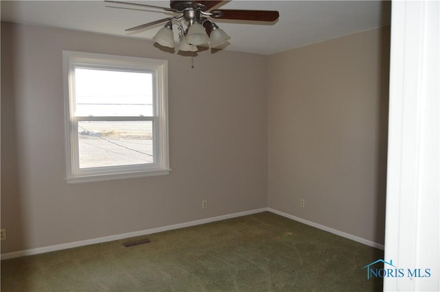 spare room featuring dark carpet and ceiling fan