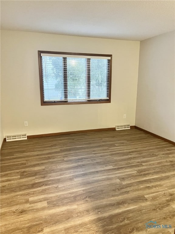 empty room with hardwood / wood-style flooring