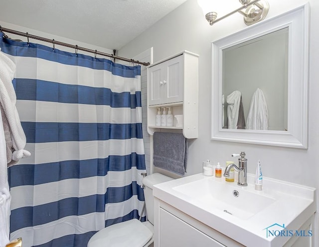 bathroom with vanity, toilet, a textured ceiling, and walk in shower