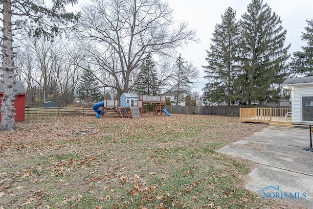 view of yard featuring a playground and a wooden deck