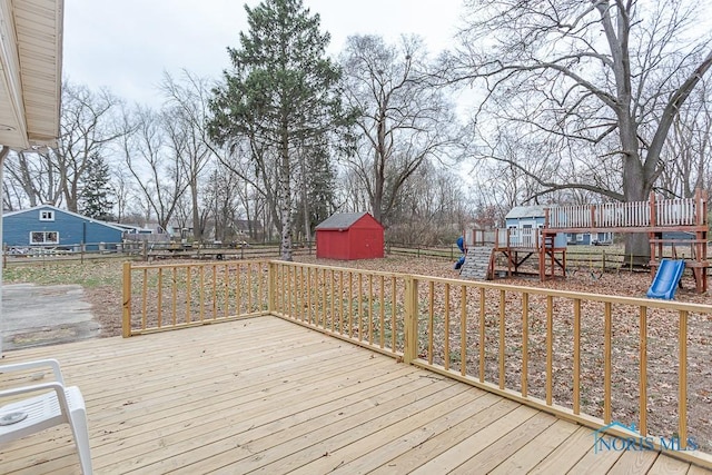 wooden deck featuring a playground and a shed