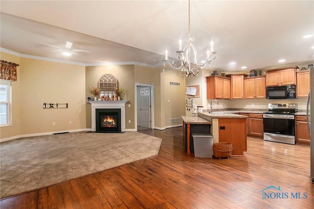 kitchen with wood-type flooring, a kitchen bar, stainless steel electric range oven, and ornamental molding