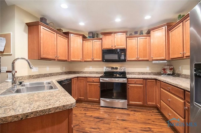 kitchen featuring dark wood-type flooring, sink, and black appliances