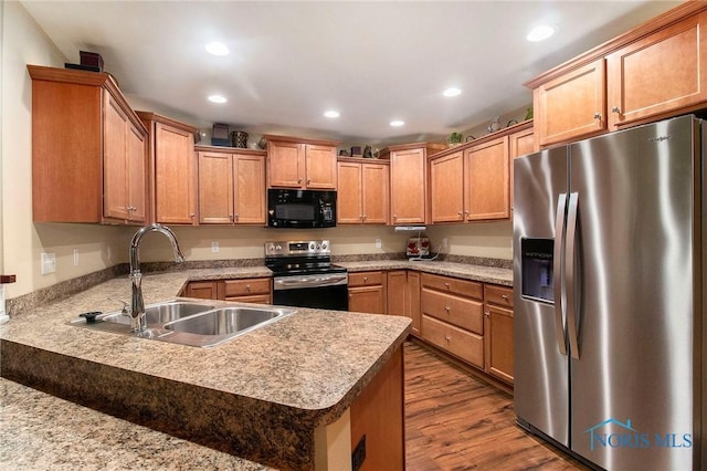 kitchen featuring wood-type flooring, stainless steel appliances, and sink