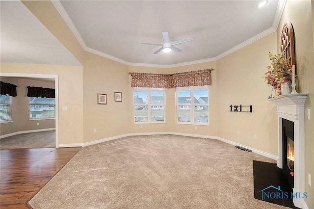 unfurnished living room with ornamental molding, ceiling fan, and a healthy amount of sunlight