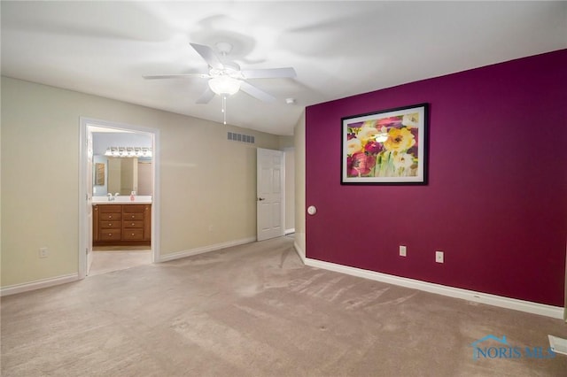 unfurnished bedroom with connected bathroom, ceiling fan, and light colored carpet