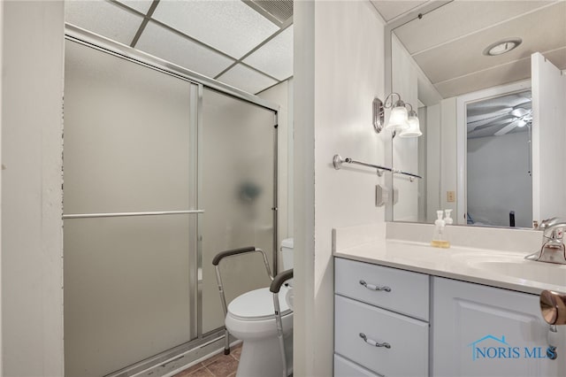 bathroom with vanity, toilet, ceiling fan, and a shower with shower door