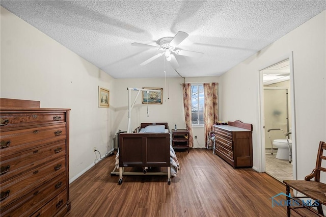 bedroom with a textured ceiling, ceiling fan, ensuite bathroom, and dark hardwood / wood-style floors