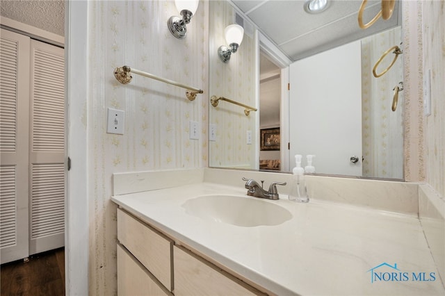 bathroom with vanity, wood-type flooring, and a textured ceiling