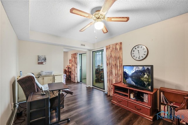 office space with a textured ceiling, ceiling fan, and dark hardwood / wood-style floors