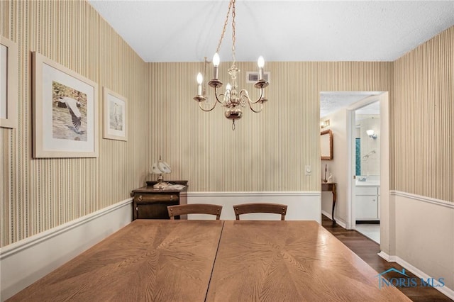 unfurnished dining area with an inviting chandelier and dark wood-type flooring