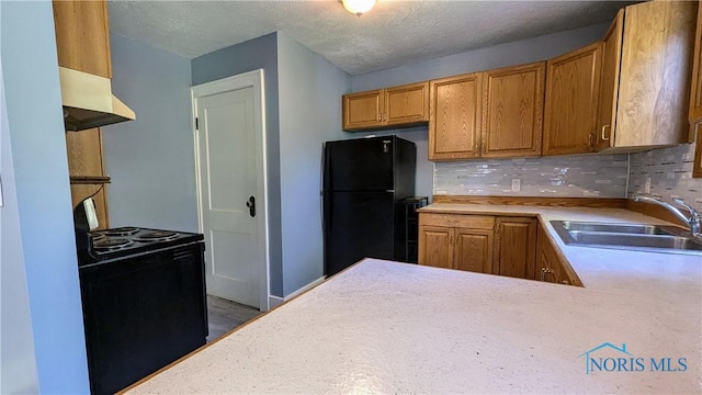 kitchen with backsplash, black appliances, sink, a textured ceiling, and kitchen peninsula