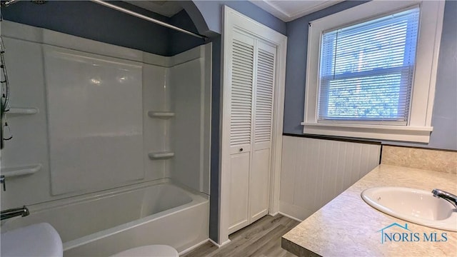 full bathroom with hardwood / wood-style floors, vanity, shower / bath combination, and toilet