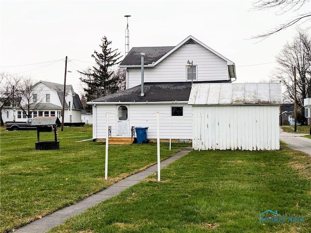 view of side of home featuring a lawn and a storage shed