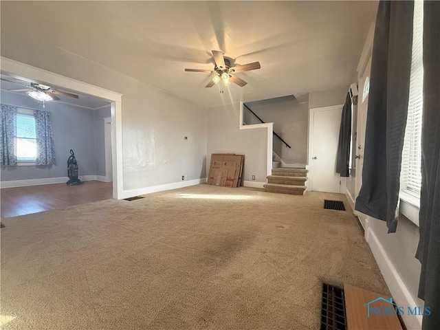 unfurnished living room featuring carpet and ceiling fan