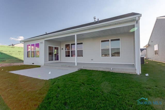 rear view of house with a yard, a patio, and central AC