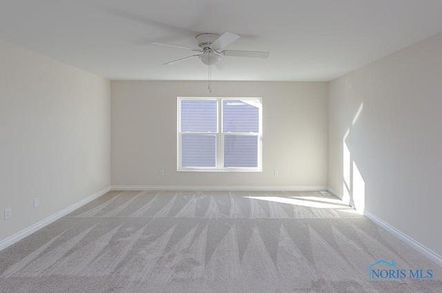 empty room featuring ceiling fan and light colored carpet