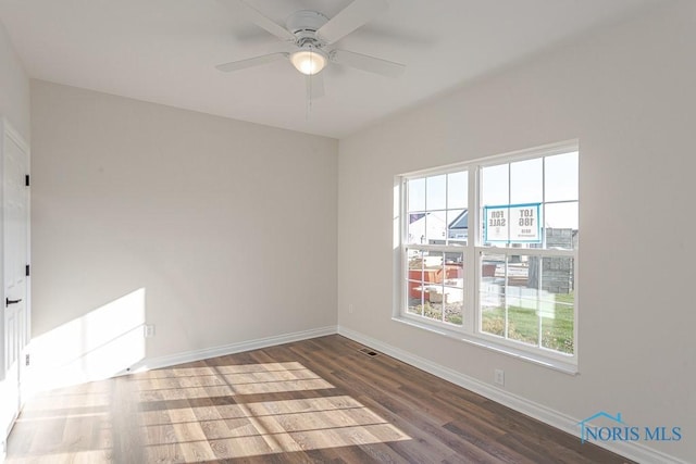 spare room featuring ceiling fan and dark hardwood / wood-style flooring