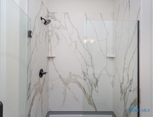 interior details featuring a tile shower