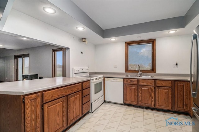 kitchen featuring kitchen peninsula, sink, and white appliances