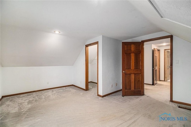 bonus room featuring lofted ceiling and light carpet