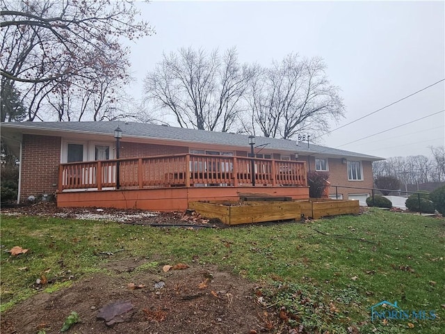 back of property with a lawn and a wooden deck