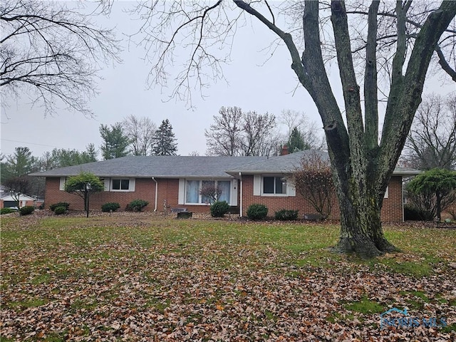 single story home featuring a front lawn