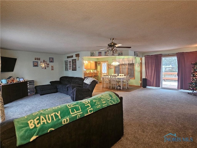 carpeted living room featuring ceiling fan and a textured ceiling