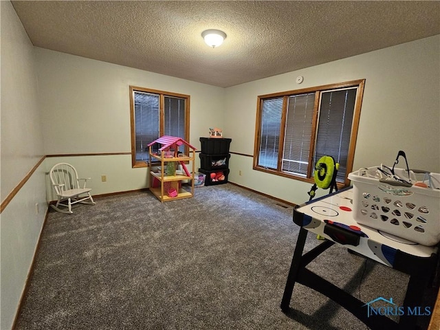 game room featuring dark carpet and a textured ceiling