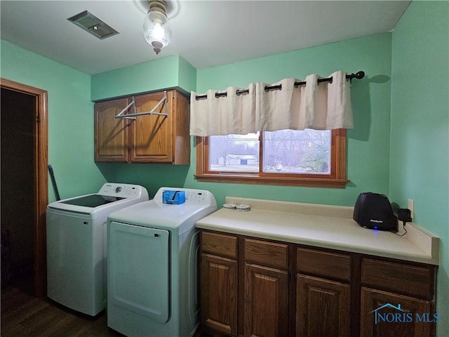 washroom featuring cabinets, dark hardwood / wood-style flooring, and washer and clothes dryer