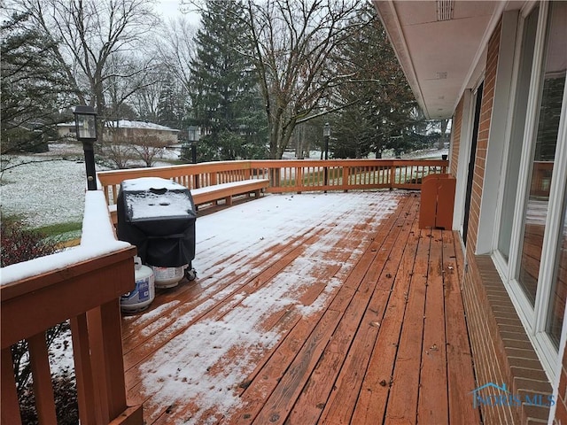 snow covered deck featuring a grill