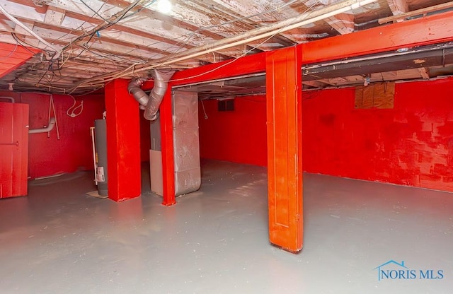 basement featuring heating unit and water heater