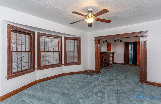 unfurnished room with ceiling fan, carpet, and a textured ceiling