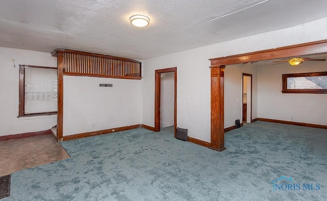 carpeted spare room featuring ceiling fan and a textured ceiling