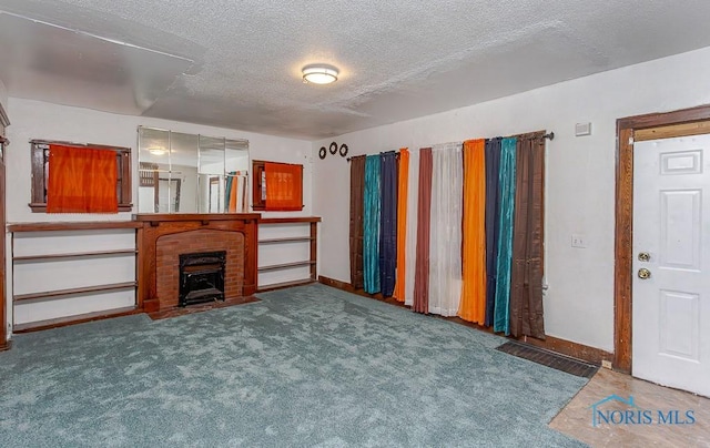 unfurnished living room featuring a textured ceiling, carpet floors, and a brick fireplace