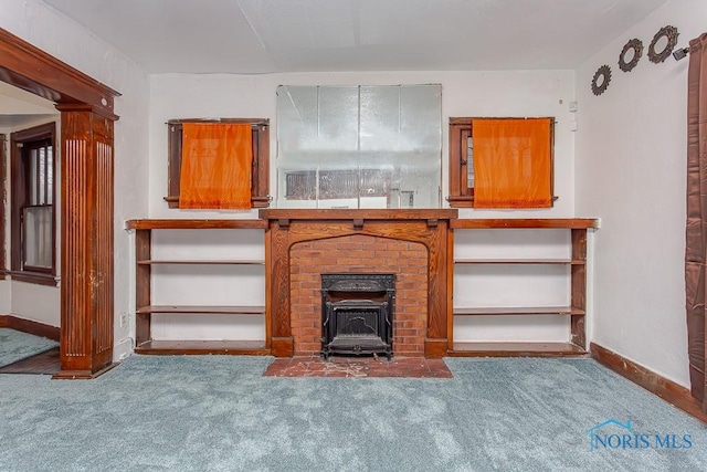 unfurnished living room featuring carpet flooring and a wood stove