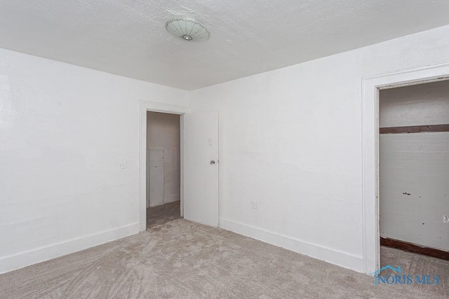 unfurnished bedroom featuring light carpet, a closet, and a textured ceiling