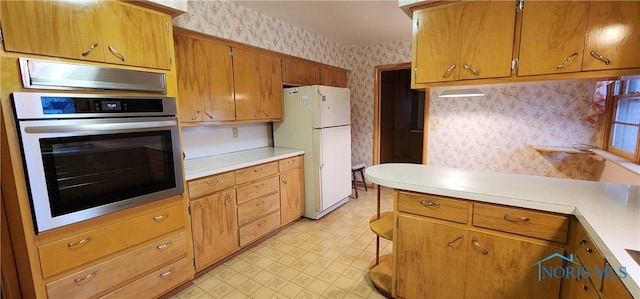 kitchen with stainless steel oven and white refrigerator