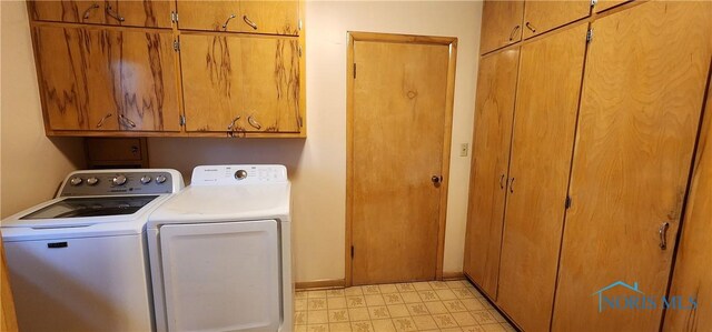 washroom with washer and clothes dryer and cabinets