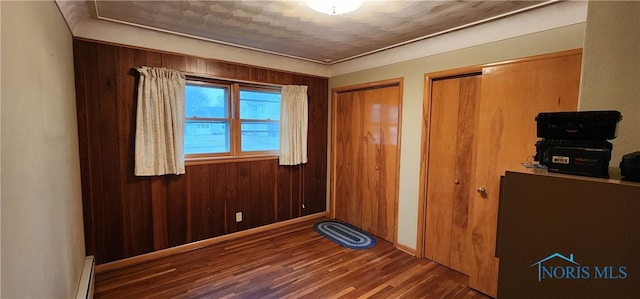 interior space featuring dark hardwood / wood-style flooring and wooden walls