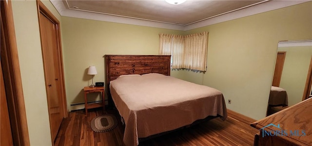 bedroom featuring dark wood-type flooring and a baseboard heating unit