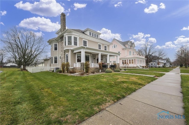 view of front of property featuring covered porch, a front lawn, and cooling unit