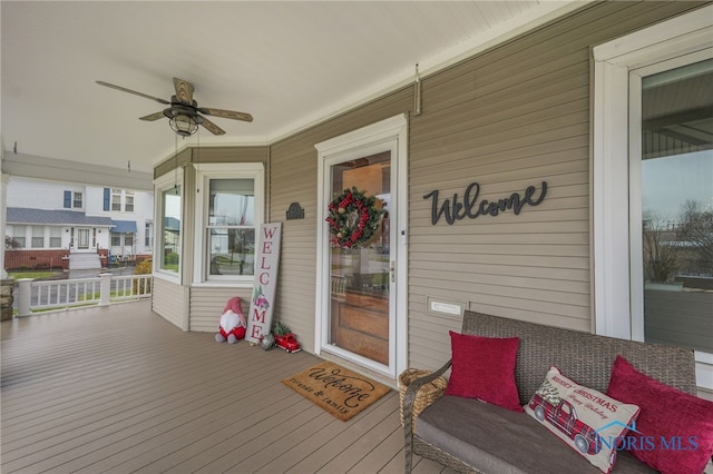 wooden terrace featuring covered porch and ceiling fan