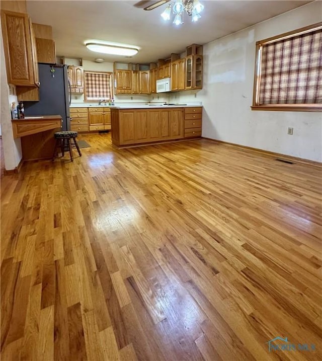 kitchen featuring kitchen peninsula, light hardwood / wood-style flooring, and ceiling fan