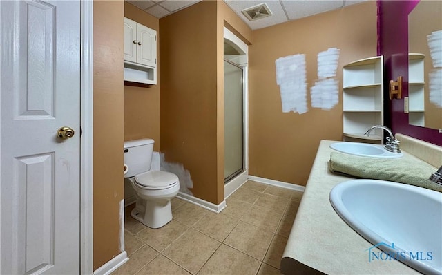 bathroom with a paneled ceiling, tile patterned floors, vanity, toilet, and a shower with shower door