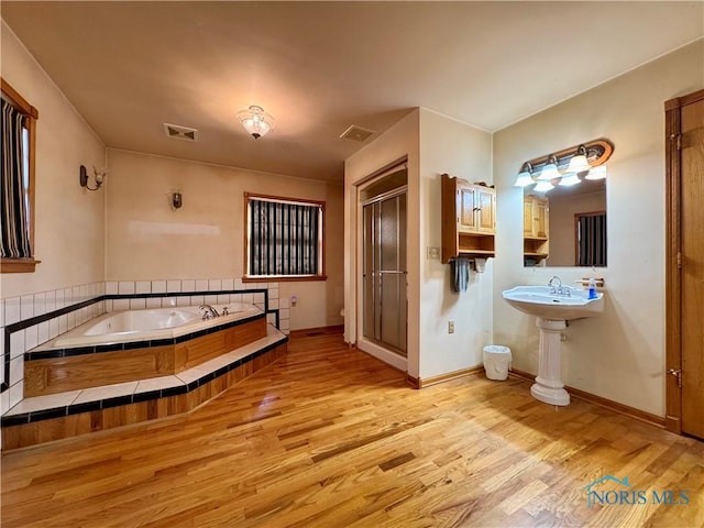 bathroom featuring plus walk in shower, wood-type flooring, and toilet