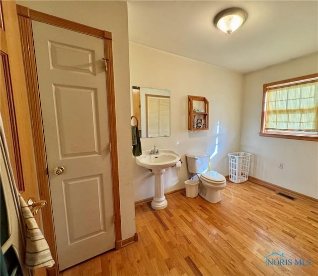 bathroom with wood-type flooring and toilet